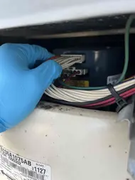 Technician checking blower wiring connections during AC repair in Sacramento