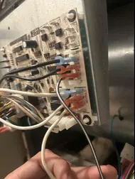 Technician inspecting wiring connections on an HVAC control board during AC repair in Rancho Cordova