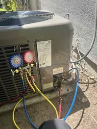Refrigerant gauges connected to an outdoor AC condenser during a cooling performance check in Sacramento